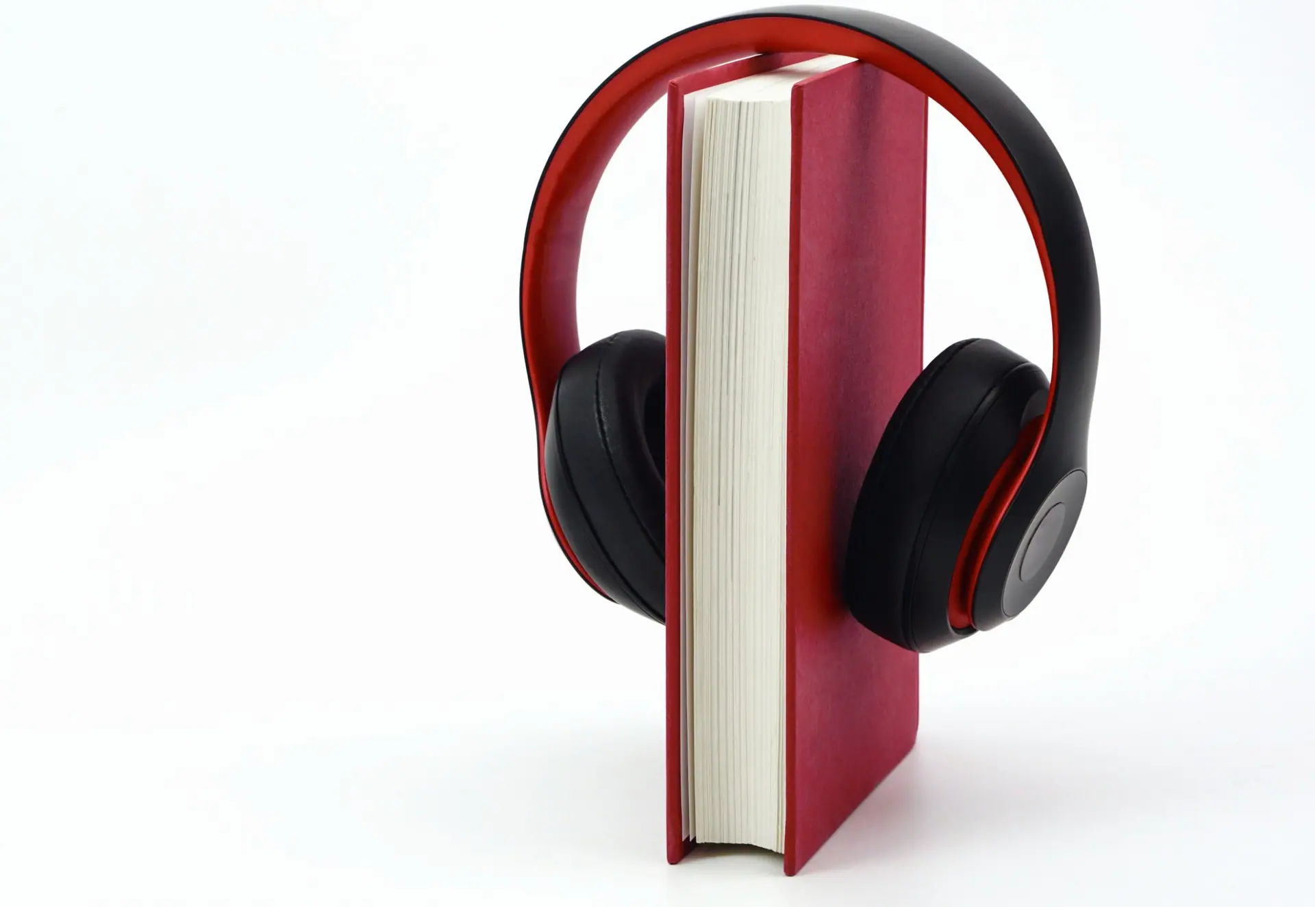 Headphones resting over a red hardcover book