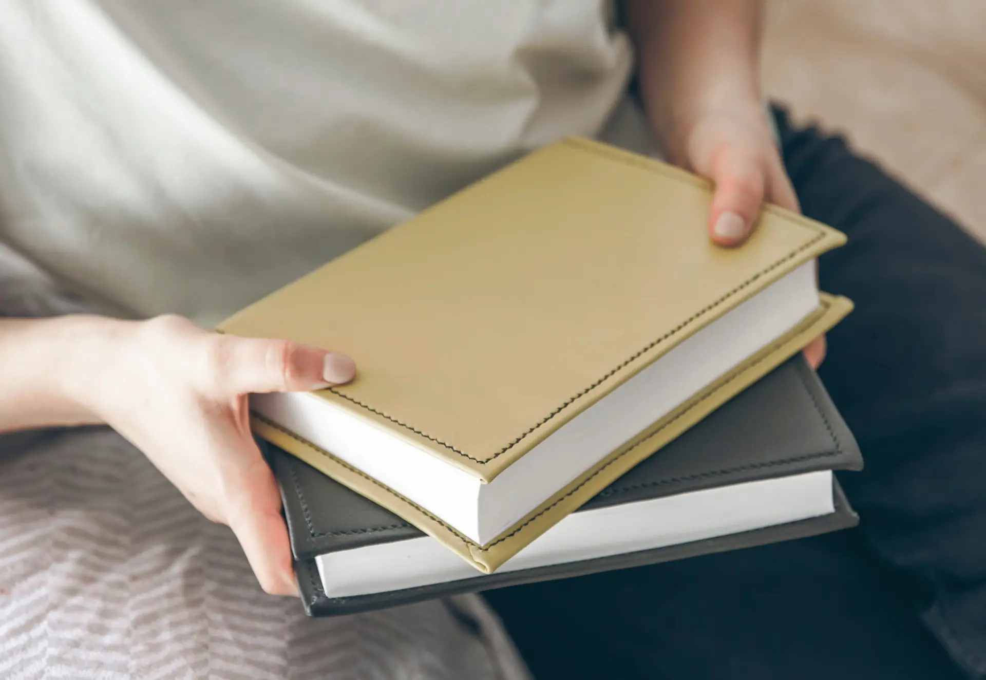 A reader holding two new clothbound hardcover books
