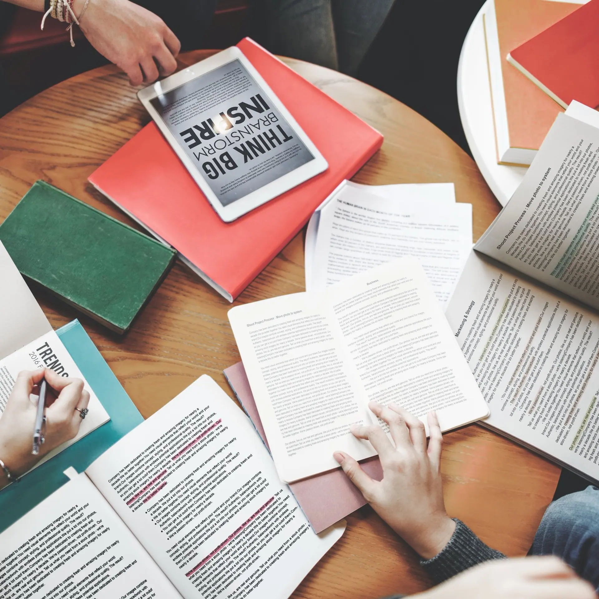 A team working around a table of marked-up pages and books