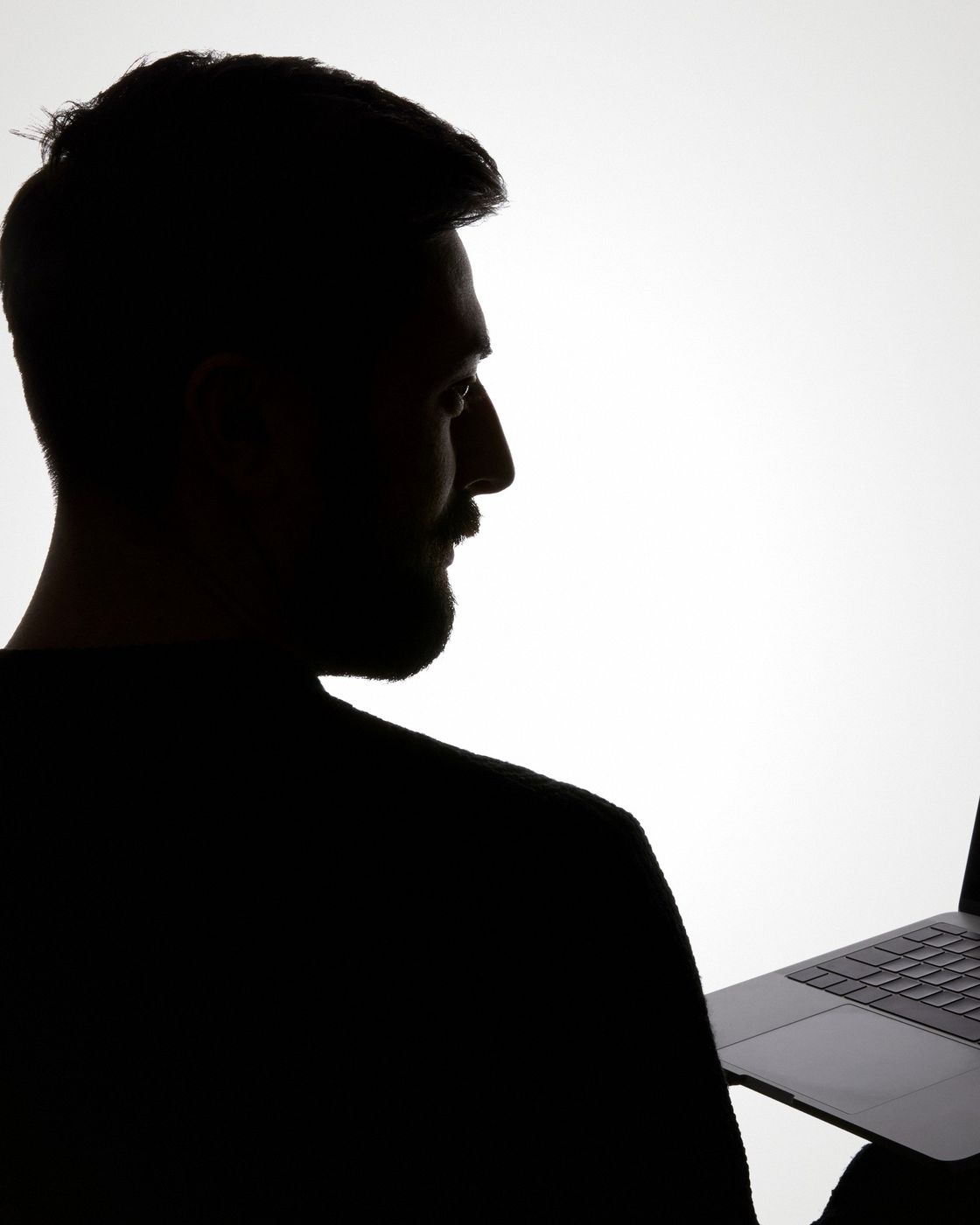 The silhouette of a writer working quietly at a laptop