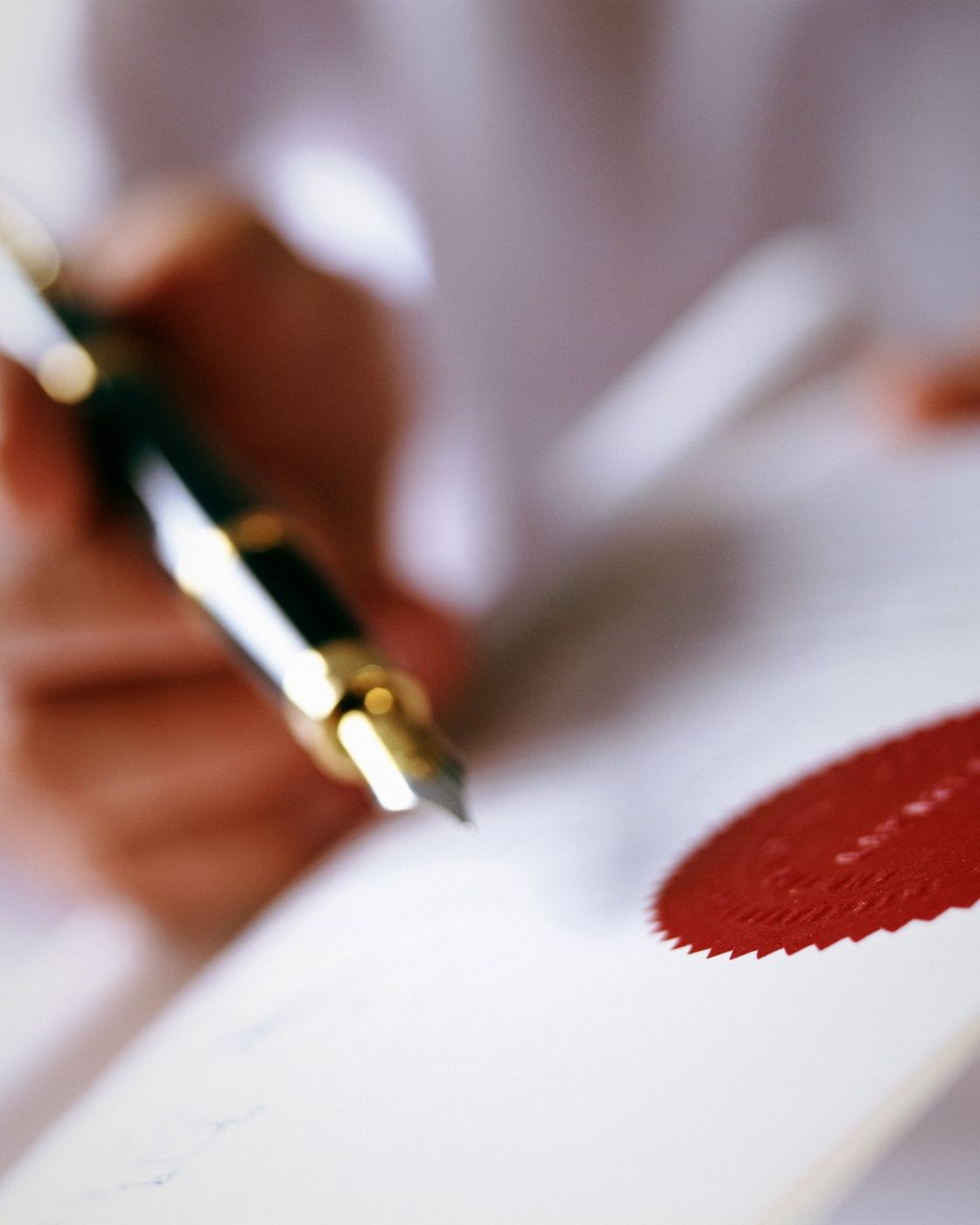 A fountain pen resting on a page of handwritten red-ink edits