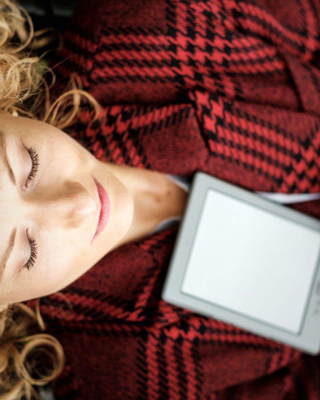 A reader with a tablet displaying an eBook beside a cup of coffee