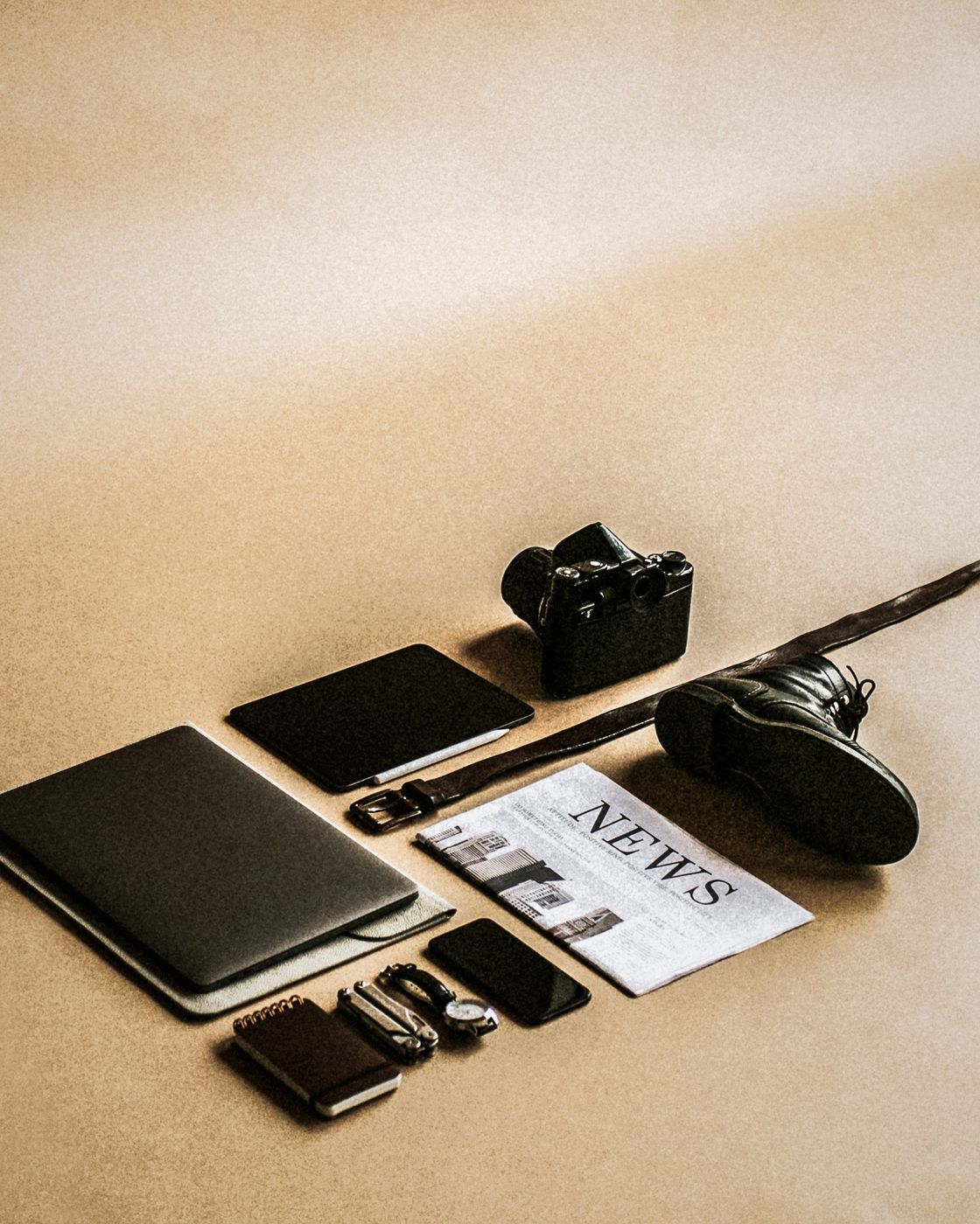 A curated flat lay of press materials: camera, notebook, newspaper clipping, and laptop