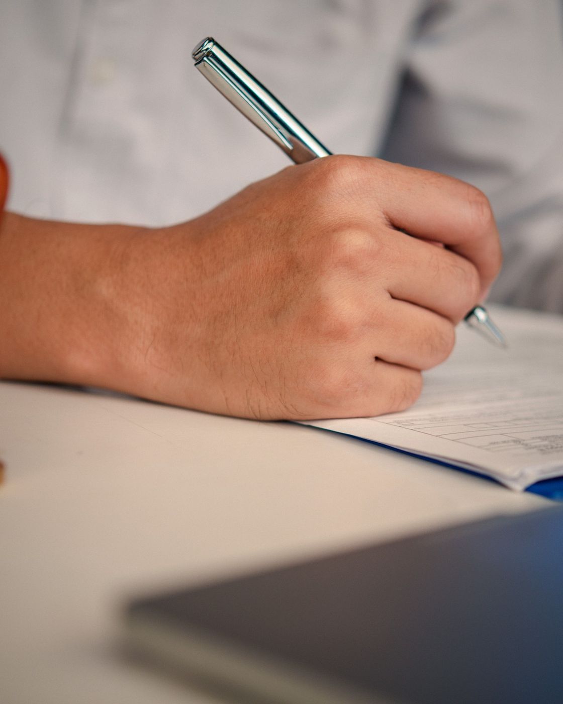 A hand signing a copyright registration document at an office desk